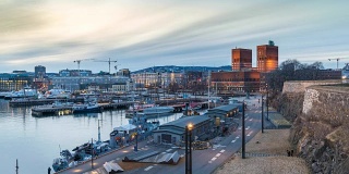奥斯陆城市天际线白天到晚上的时间流逝在奥斯陆市政厅和海港，奥斯陆挪威4K时间流逝