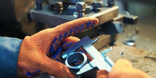 工业工人在金属加工工厂的加工过程中，在机器上进行机械车削操作