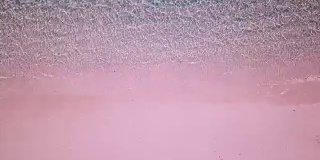 粉红色的海滩水晶清澈的水在科莫多国家公园印度尼西亚鸟瞰图4K