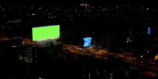 广告牌绿色屏幕与城市夜间交通灯背景。泰国曼谷。4 k决议。