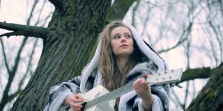 白人女模特看着天空，弹着吉他