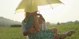 慢镜头:在凉爽的夏雨中，年轻的情侣拥抱亲吻。