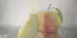 红苹果在水中切成薄片。慢动作镜头