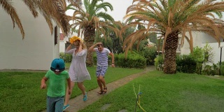 雨中父母和孩子在院子里奔跑