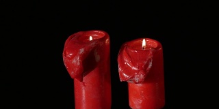 近3个点燃的红色蜡烛旋转在黑色的背景
