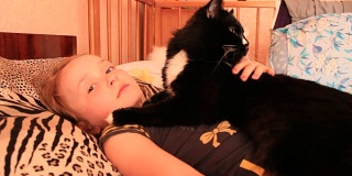 小女孩和她的猫一起躺在床上。和你的宠物一起