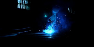 特写工业工人在工厂焊接，工人在工业工厂焊接