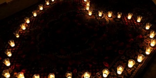炽热的心。蜡烛排成心形。动画背景与发光的蜡烛在一个心形的电影关于情人节或关于婚礼的电影。无缝循环动画