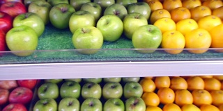 人们从超市货架上拿新鲜水果