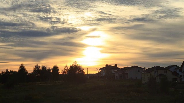 美丽的日落，阳光和云彩在村庄上空
