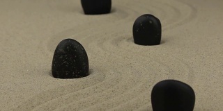 放大。黑色的石头歪歪扭扭地躺在沙地上