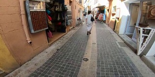 在法国比利牛斯东部的科利乌尔市，一名穿着裙子的年轻女子走在街道上