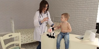 小儿科医生在注射前和男孩玩。