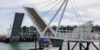 4K时间流逝:新西兰奥克兰市的大桥升起，船只经过。