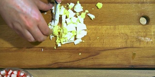 手切鸡蛋的特写。在一个黄色的厨房板上。