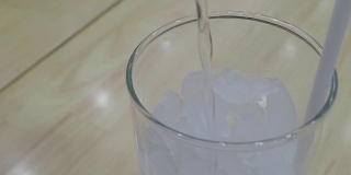 在玻璃杯中倒入干净的饮用水以澄清冰块