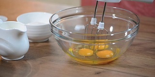 把鸡蛋放在碗里。用搅拌器搅拌鸡蛋