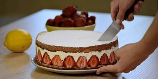 用刀切一片草莓蛋糕