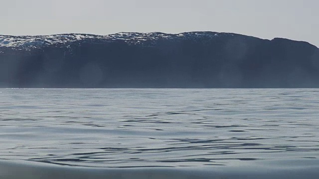 从平静海面上一艘船的舷窗里