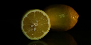 两个柠檬躺在黑暗的背景上