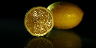 两个漂亮多汁的柠檬放在深色的表面上