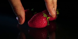 那只手从桌上拿起草莓