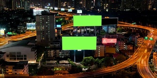 4K时间推移:广告牌绿色屏幕与城市夜间交通灯背景。泰国曼谷。4 k决议。