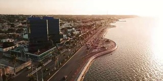 美丽的日落在大海和城市。Campeche Malecon和海上鸟瞰图。海滨的跑步机和自行车道
