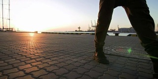 近距离拍摄的不认识的人走在海港在日落日出，慢动作