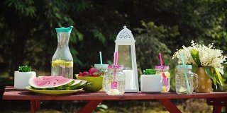 野餐桌上有多汁的水果和美味的柠檬水