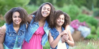 三个非裔美国姐妹在花园里微笑