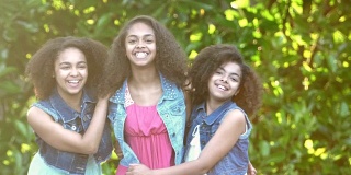 三个非裔美国姐妹在花园里大笑