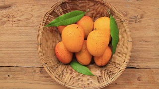 有机芒果热带水果篮子放在木制的背景视频素材模板下载