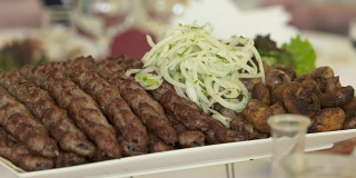 餐厅餐桌上的亚美尼亚卢拉烤肉配洋葱丁