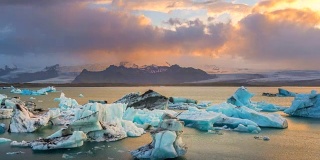 日落时分，冰岛东南部Vatnajkull国家公园附近Jökulsárlón冰川泻湖水域中的冰川。缩小。4 k UHD间隔拍摄。