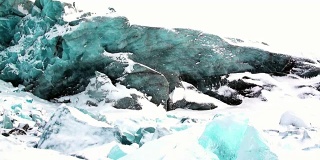 Glacier of beautiful unique turquoise color on background of snow in Arctic.
