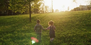 孩子们手牵着手一起走在草地上，阳光明媚的夏日