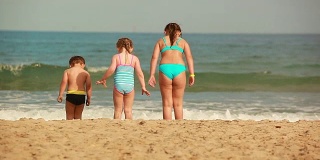 两个女孩和一个小男孩在玩沙子