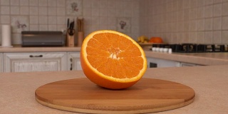 近距离的切片橙子。橙色的一半。以白色厨房为背景的旋转相机。Dolly-shot。