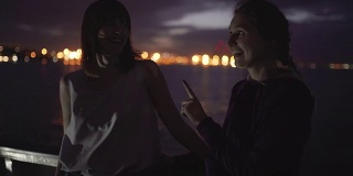 两个迷人的年轻女人的剪影在夜里在船上旅行。船上的闺蜜