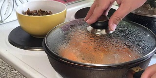一个女人正在做炸丸子。炸馅蘑菇馅。在烤盘上做出形状，加入蘑菇，肉末和奶酪。时间流逝。