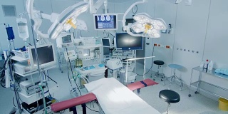 拍摄技术先进的手术室，没有人，准备手术。拥有工作设备、灯光和电脑的真正现代手术室为外科医生和病人准备好了。