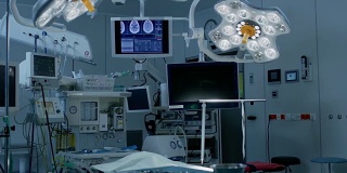 拍摄技术先进的手术室，没有人，准备手术。拥有工作设备、灯光和电脑的真正现代手术室为外科医生和病人准备好了。