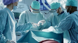 外科医生戴着虚拟现实眼镜在技术先进的医院进行最先进的手术。在手术室工作的医生和助手。视频素材模板下载