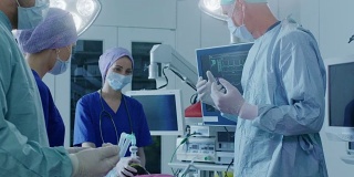 不同的外科医生和助理团队走进手术室，病人在那里等待，他们把他麻醉并开始手术。真正的现代医院与真实的设备。