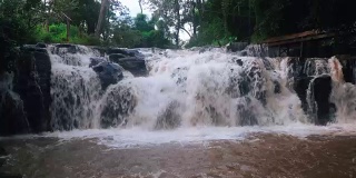 白色的水流过巨大的黑色岩石(小瀑布)