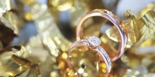 微距拍摄的结婚戒指与金色纹理的背景。