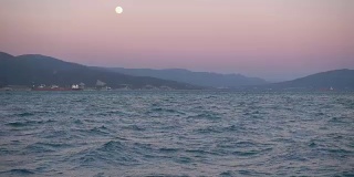 美丽的日落，山和海的一轮明月。