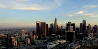 黄昏时分，无人机摄影车从洛杉矶市中心的天际线出发