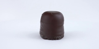 巧克力覆盖棉花糖-巧克力软旋转在转盘上。孤立在白色背景上。